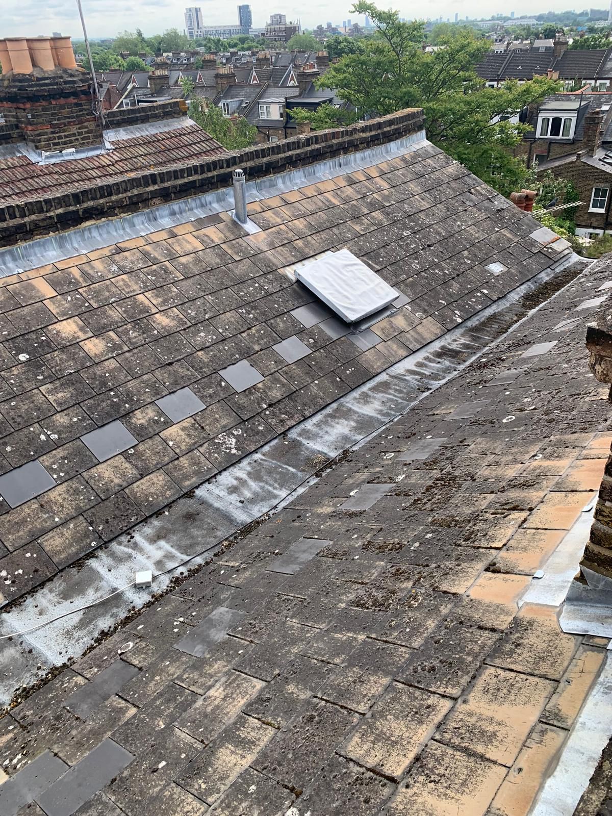 Aged slate roof with mossy tiles before repair in Richmond